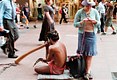 2000 Sydney. Aboriginal speelt de didgeridoo, vriendin breit
