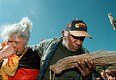 2000 Australië. Aboriginals blazen symbolisch de Olympische vlam uit