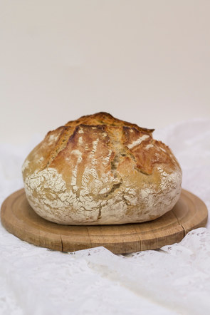 Wheat bread in roman pot on wooden board. White background.