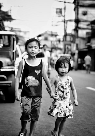 Brother and sister, strolling down the street.